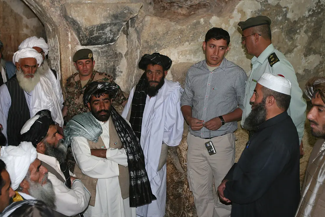 Afghan men listen to a story while on a tour inside the Cave of the Seven Sleepers in Amman, Jordan, April 21, 2011 110421-M-GW940-078